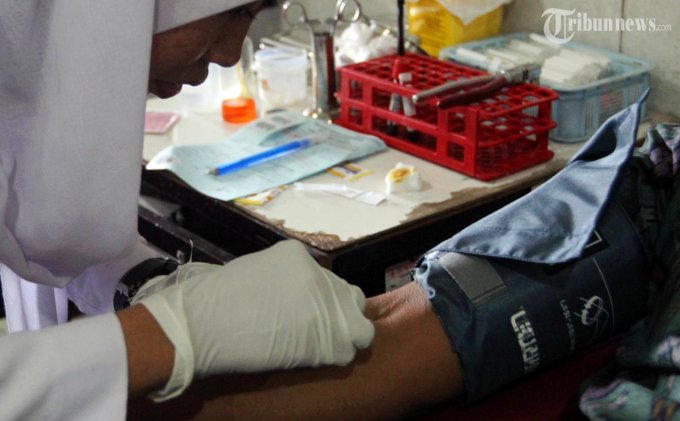 Terinveksi HIV: Petugas Palang Merah Indonesia (PMI) Kota Semarang mengambil darah dari pendonor, Rabu (4/12/2013). Dari Januari hingga November 2013 PMI Kota Semarang menemukan 76 kantong darah terinveksi HIV. Pasokan darah untuk 2014 masih terbilang aman, data yang diambil selama 2013 PMI Kota Semarang mendapatkan 56.203 kantong darah. (Tribun Jateng/Wahyu Sulistiyawan) 