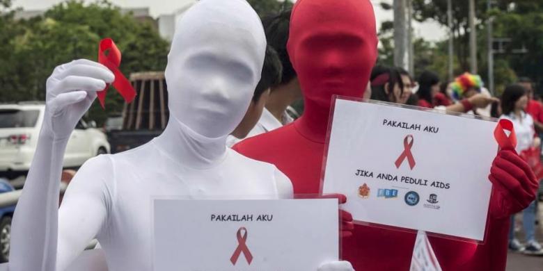 AFP PHOTO / JUNI KRISWANTO Aktivis membawa pita merah dalam kampanye Hari AIDS Sedunia, di Surabaya, Senin (1/12/2014). Sekitar 45.000 kasus HIV/AIDS terjadi di Indonesia sepanjang 2013 dan 14.400 kematian di tahun yang sama.